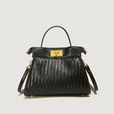 Black woven handbag with gold accents on a light gray background